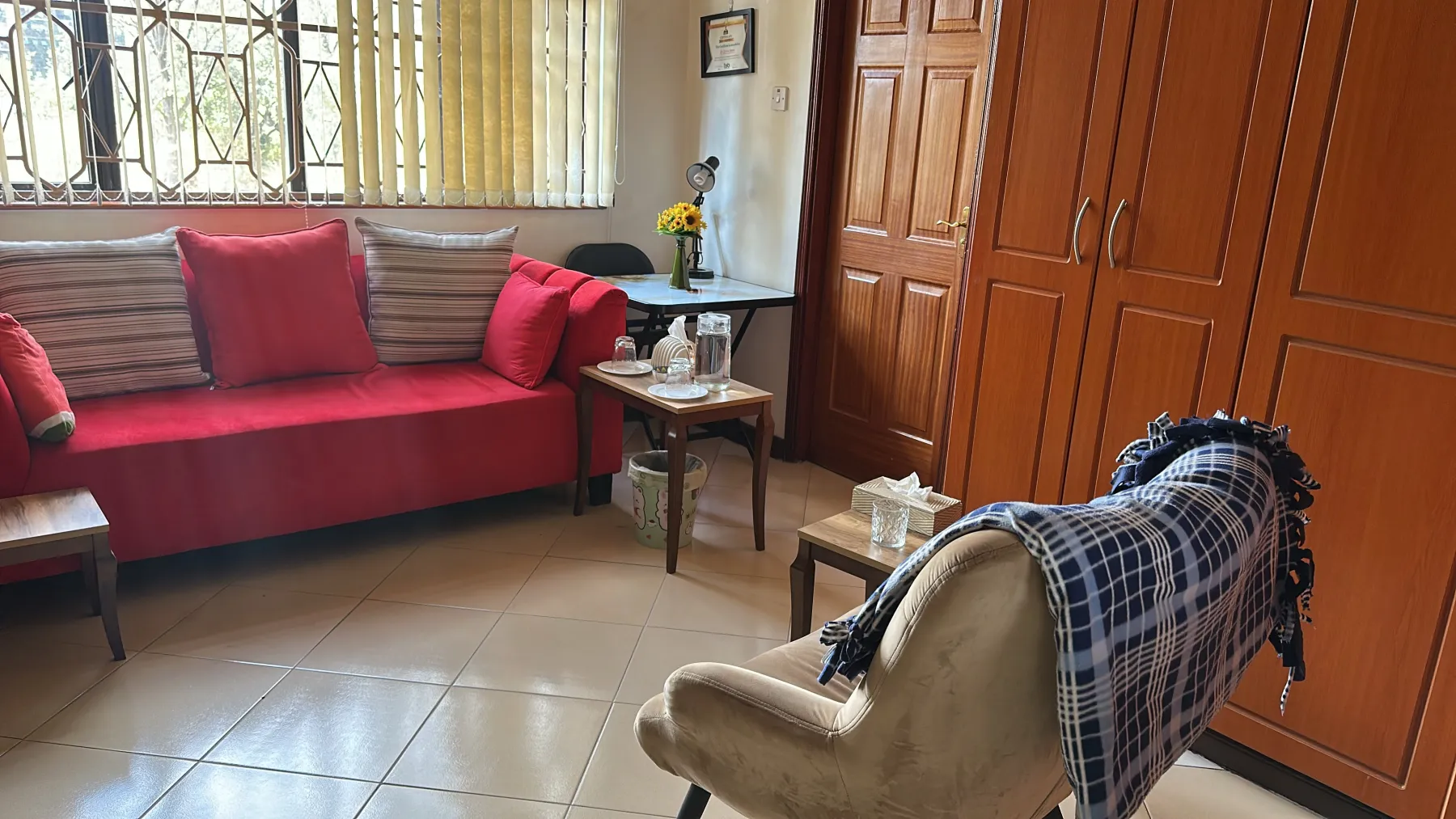 Blossom therapy room with a red sofa, armchair and sunflowers by the window